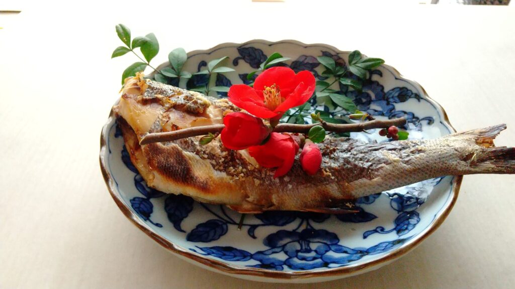 焼き魚と梅の花
