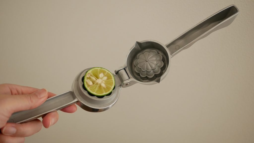 すだち絞り器に半分に切られたすだちが入っている