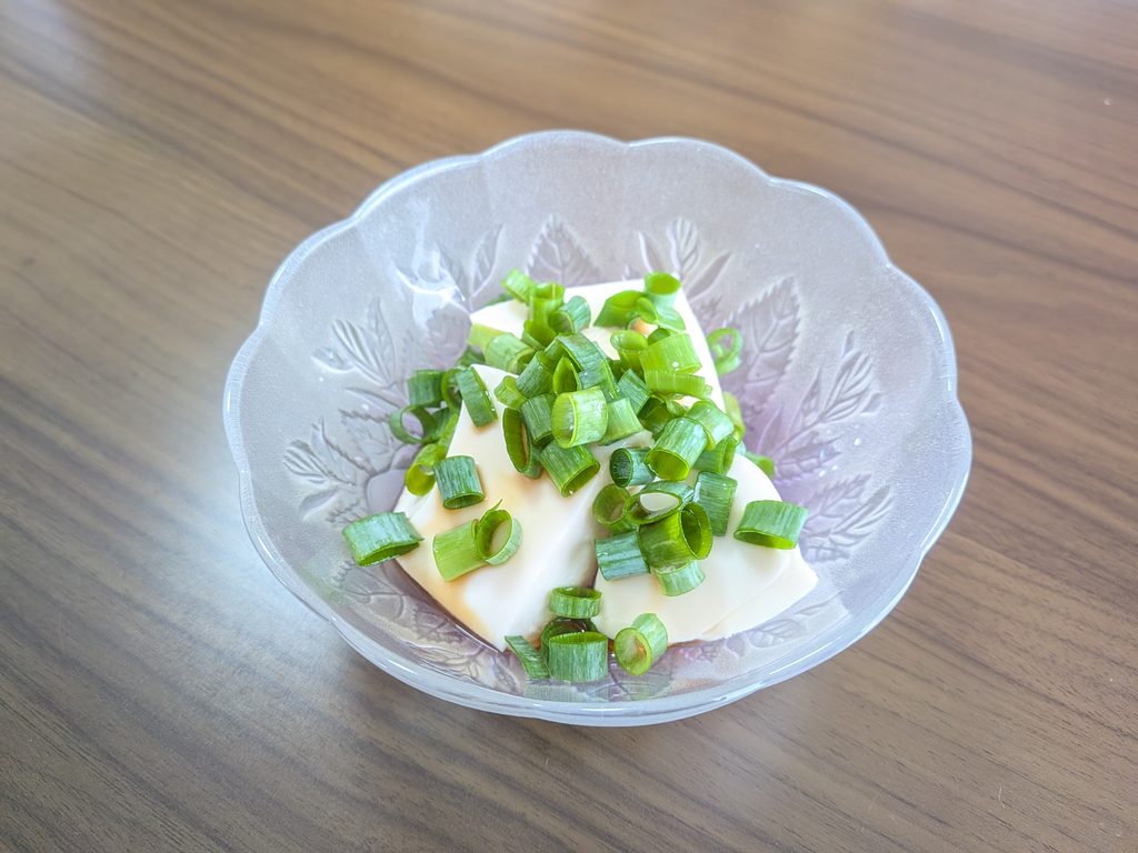 冷ややっこに青ねぎをのせている